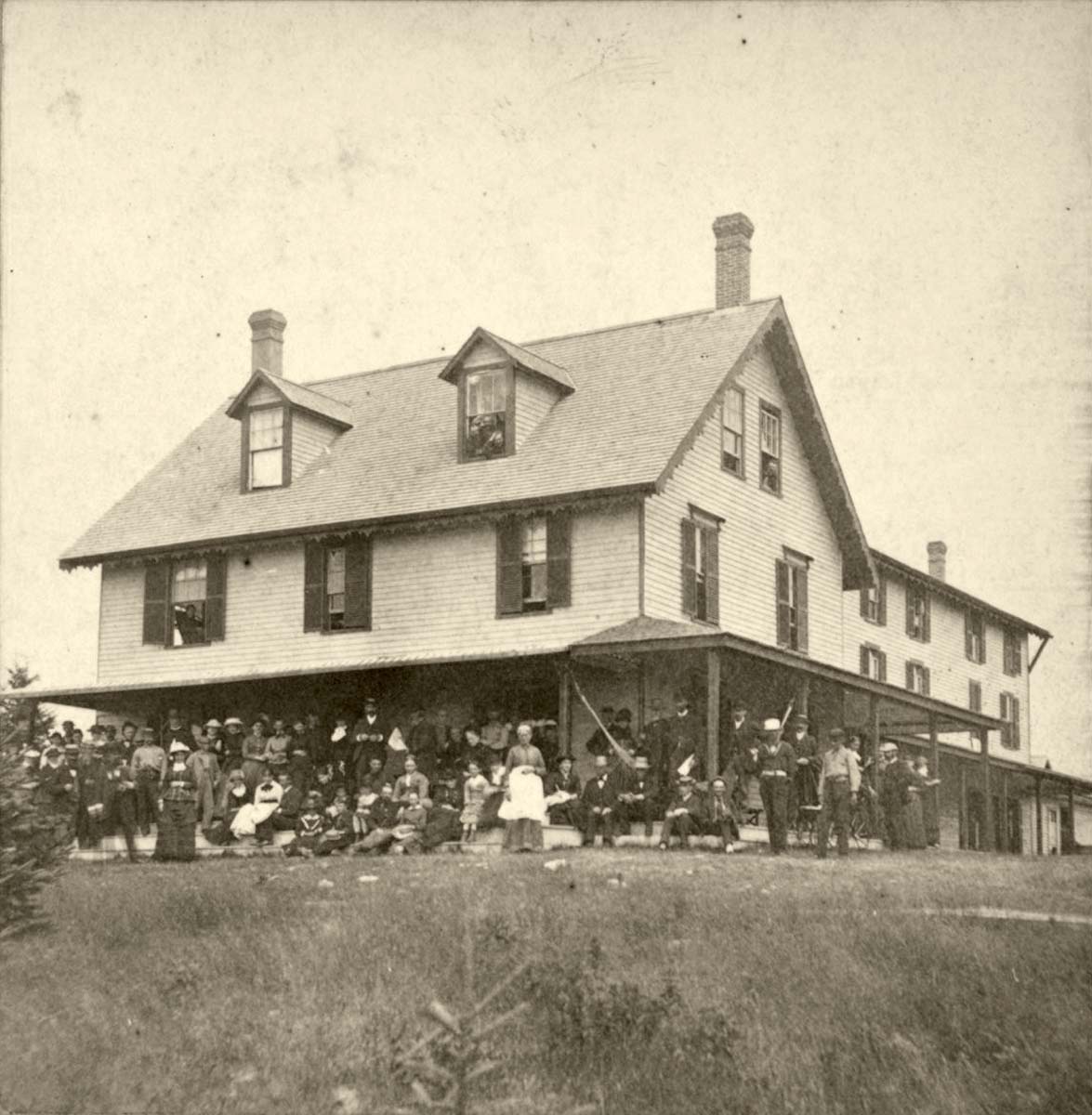 Augusta. People posed on the porch of a three-store house