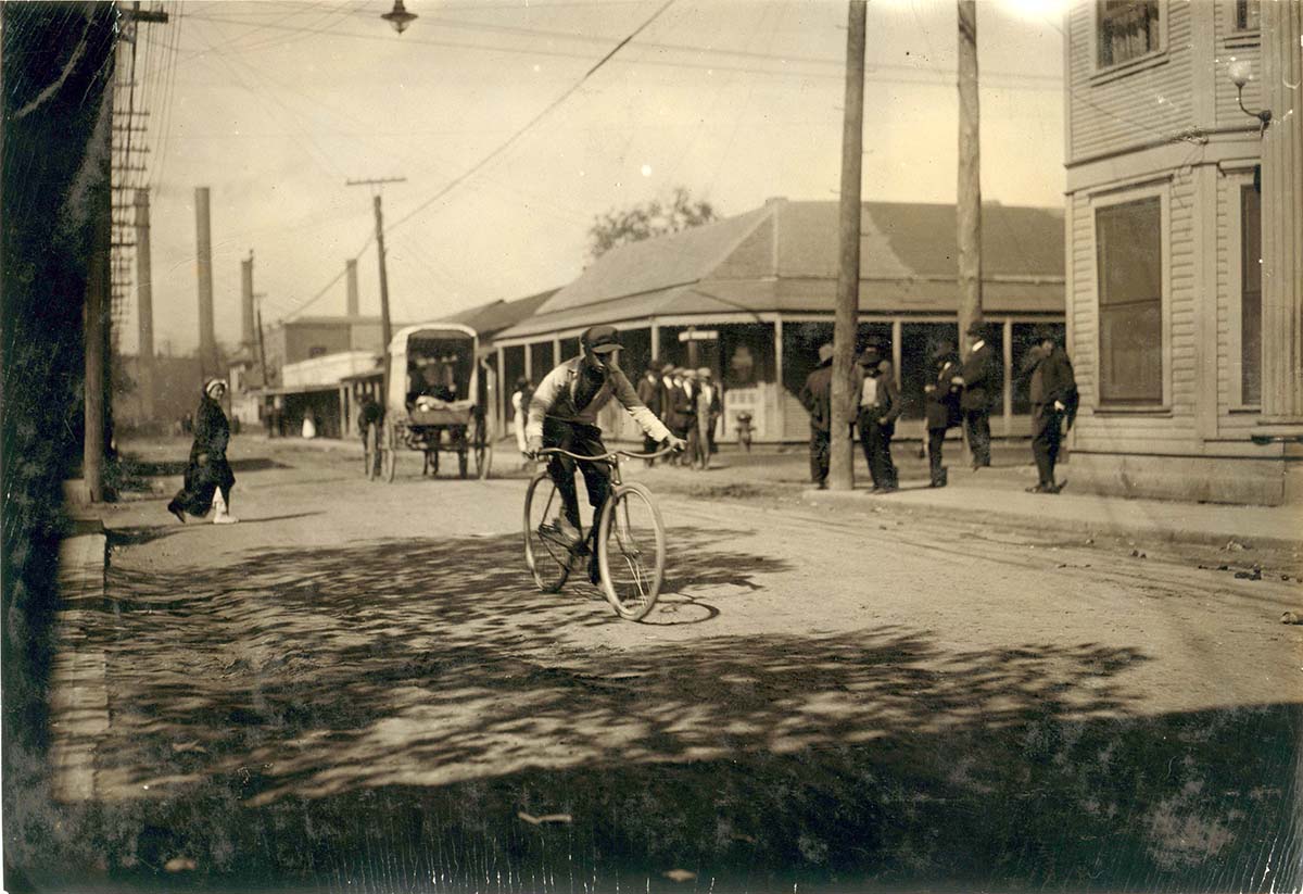 Dallas, Texas. Messenger boy in the heart of the Reservation, prostitutes run back and forth, 1913